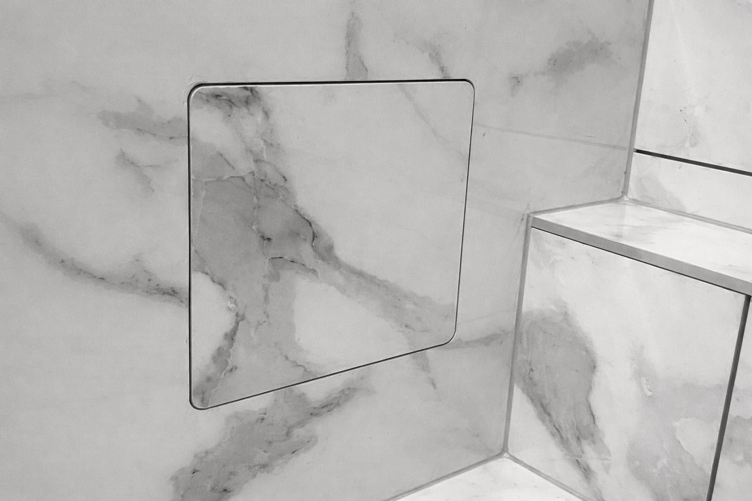 Faïence effet marbre blanc veiné, avec une niche de rangement encastrée dans la douche