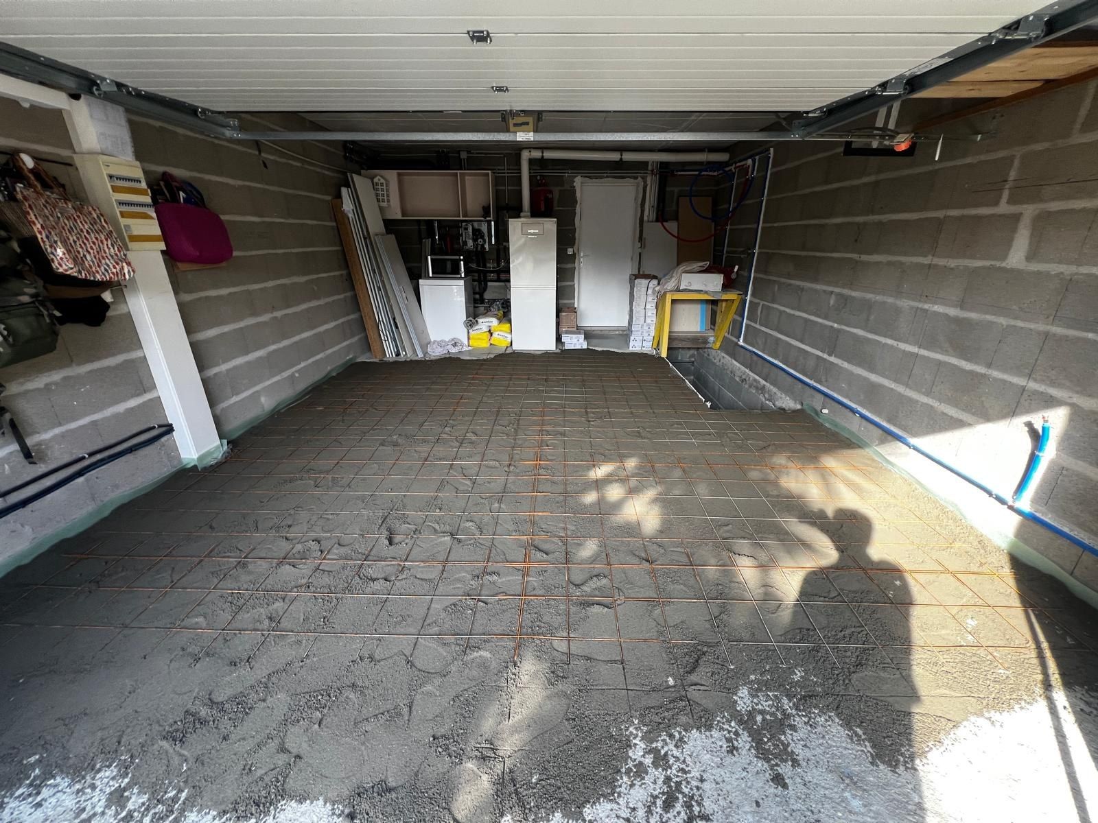 Avant travaux : sol de garage irrégulier, ancien carrelage cassé et reprises de béton apparentes